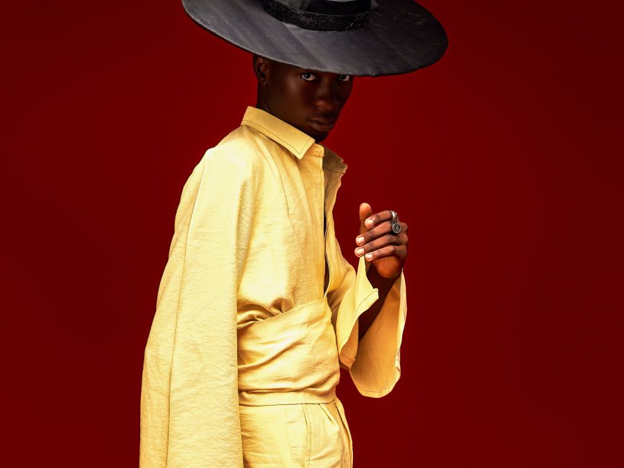 Fashion model in a yellow suit against a red background