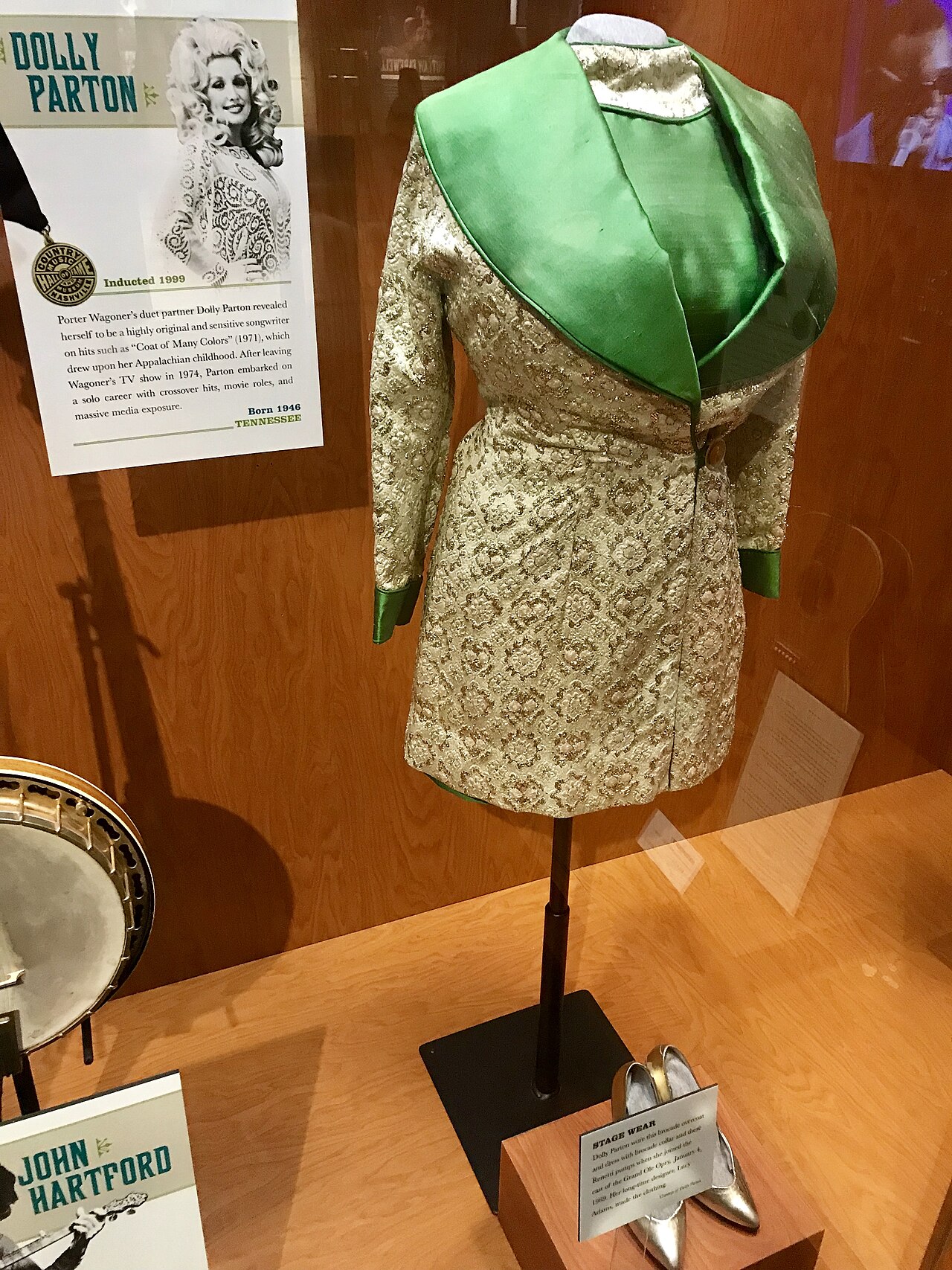 Dolly Parton’s green-and-gold brocade Grand Ole Opry stagewear displayed in a museum
