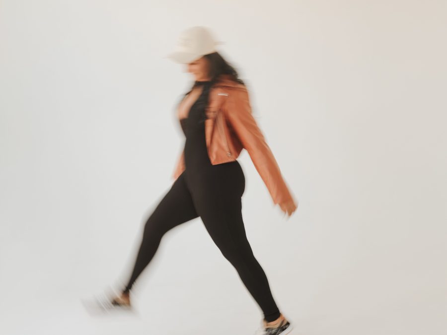 Fashion model in an orange coat captured with layered motion blur