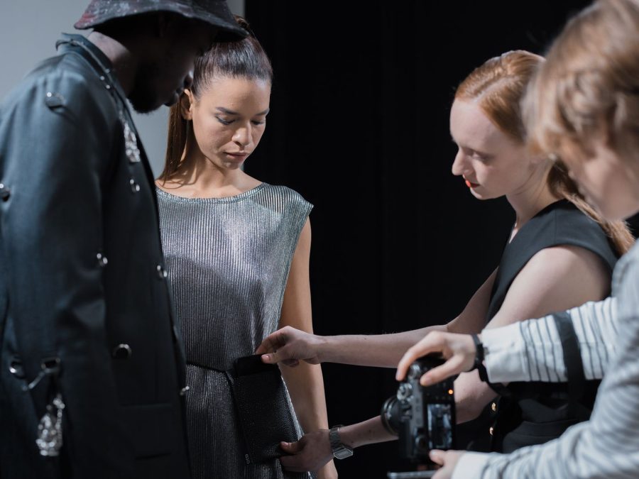 Fashion team styling a model and reviewing a camera during a campaign shoot