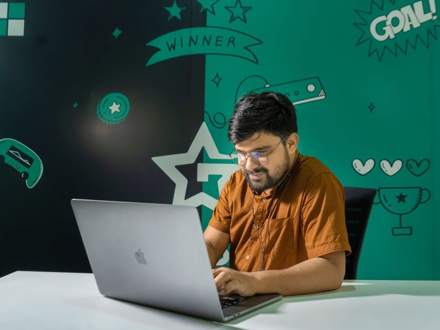 Creator working on a laptop with gaming graphics while designing digital clothing